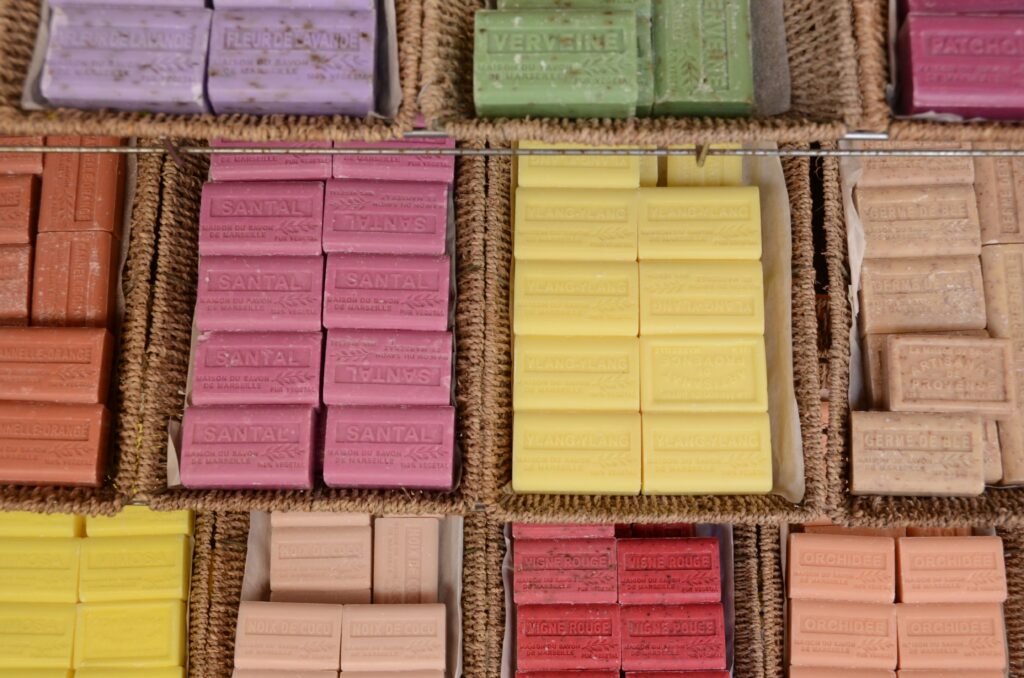 A vibrant display of handmade soaps in various colors and scents at a market.